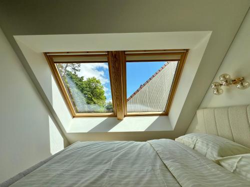 a bedroom with a window and a bed at White Penthouse Juodkrante in Juodkrantė