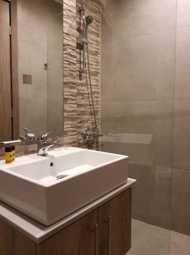 a bathroom with a white sink and a shower at Cleopatra Apartments in Hersonissos