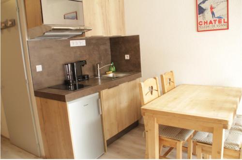 a small kitchen with a sink and a table at Chaumière des Neiges CM1003 COSY & NATURE 4 Pers in Châtel