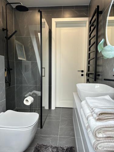 a bathroom with a white tub and a sink at White Penthouse Juodkrante in Juodkrantė