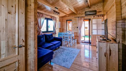 a living room with a blue couch in a log cabin at Morska Cisza in Pleśna