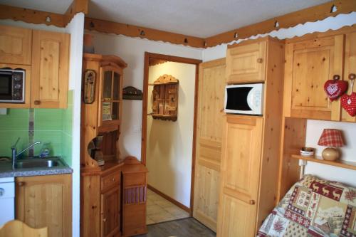 une cuisine avec des armoires en bois et un évier dans l'établissement Christina CR12 FAMILY & QUIET 4 Pers, à Châtel
