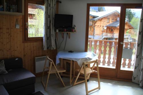 d'un salon avec une table et un balcon. dans l'établissement Christina CR19 FAMILY & MOUNTAIN 3 Pers, à Châtel