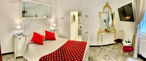 a bedroom with a bed with red pillows and a mirror at Casetta Ambretta in Monterosso al Mare