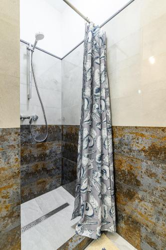 a shower curtain is hanging in a bathroom at Locmana nams in Liepāja