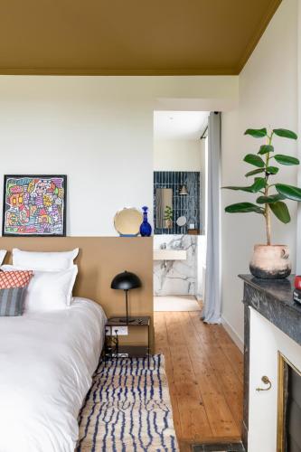 a bedroom with a bed and a fireplace at Maison Groleau in Mombrier