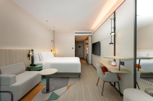 a hotel room with a bed and a couch at EVEN Hotel Qingdao Laoshan - an IHG Hotel in Qingdao