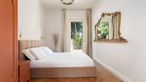 カマイオーレにあるCASA AMARE 4&2, Emma Villasのベッドと鏡のある白い寝室