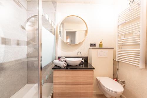 a bathroom with a sink and a toilet and a mirror at Les Cimes du Corbier - Proche des stations de ski in Villarembert