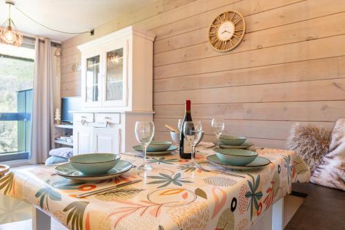 - une table avec une bouteille de vin et des verres dans l'établissement Les Cimes du Corbier - Proche des stations de ski, à Villarembert
