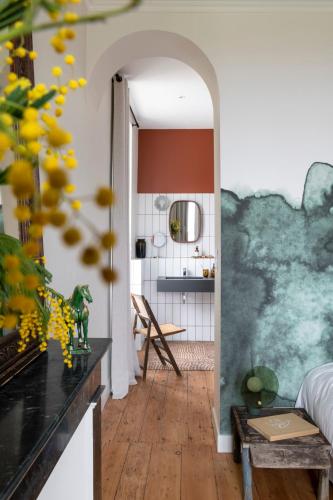 a living room with a hallway with a table and a kitchen at Maison Groleau in Mombrier