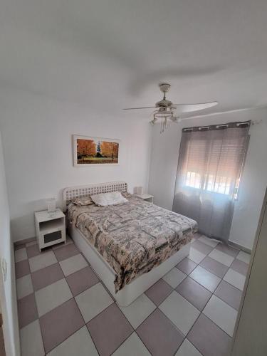 1 dormitorio con 1 cama y ventilador de techo en Apartamento vacacional, en Benalmádena