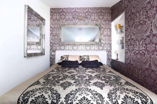 a bedroom with a large bed with purple wallpaper at Casa Giulia in Monterosso al Mare