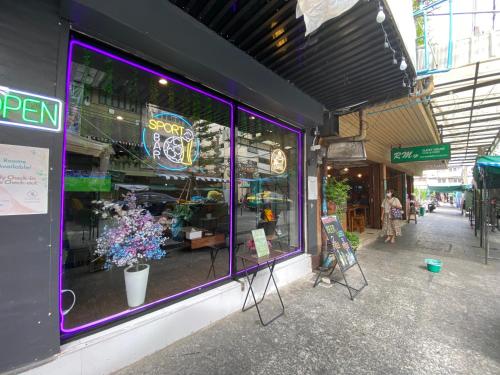 Una ventana morada de una tienda con flores. en Bud Brew Beyond Dispensary and Hotel, en Bangkok