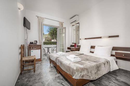 a hotel room with a bed and a balcony at Erato Hotel in Agia Marina Aegina