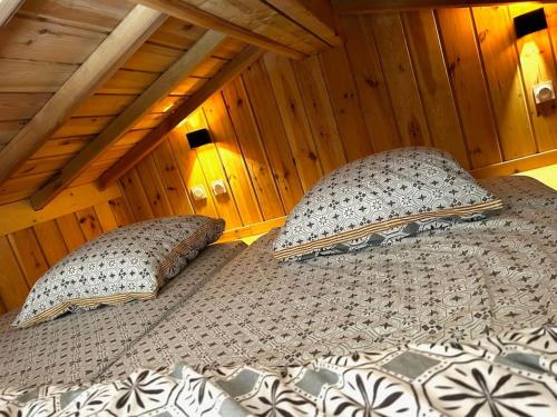 deux lits dans une chambre aux murs en bois dans l'établissement Casa Leo, à Gujan-Mestras