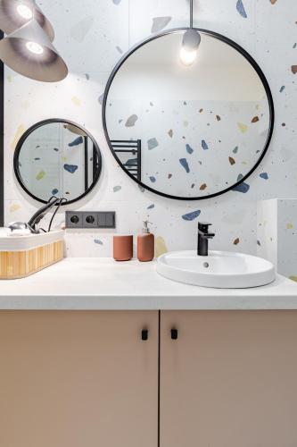 a bathroom with a sink and a mirror at Mińska Apartament in Warsaw