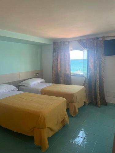 a hotel room with two beds and a window at Casa Vacanze Elianto in Anzio