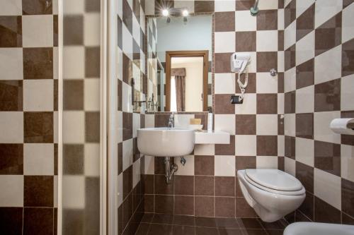 a bathroom with a sink and a toilet and a mirror at Hotel Ciao in Rome