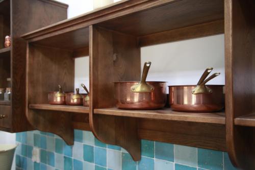 a row of copper pots on a shelf in a kitchen at Casa Letizia in Brtonigla
