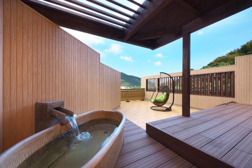 a bath tub sitting on a deck with a view at 御宿瑞鷹 in Atami