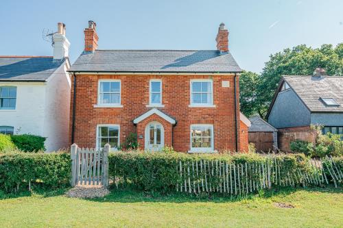 a brick house with a fence in front of it at Beautiful Cottage in Brockenhurst with Forest View in Brockenhurst