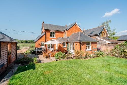 a large brick house with a patio in the yard at Beautiful Cottage in Brockenhurst with Forest View in Brockenhurst