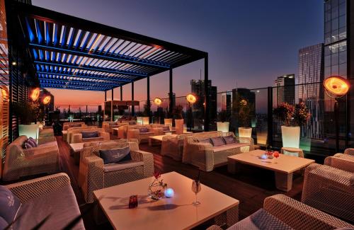 patio na dachu z kanapami i stołami w budynku w obiekcie NYX Hotel Warsaw by Leonardo Hotels w Warszawie