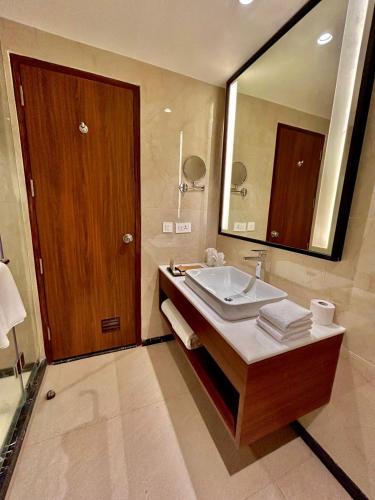 a bathroom with a sink and a large mirror at Best Western Plus Amritsar in Amritsar