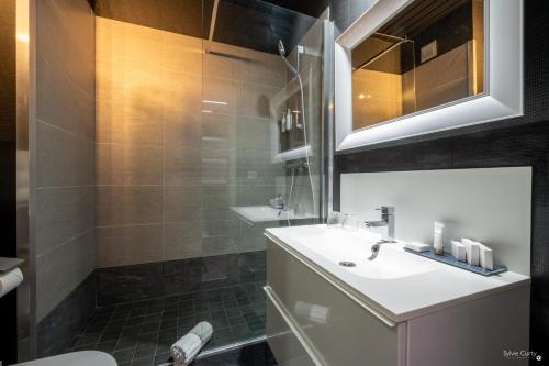 a bathroom with a sink and a shower at Hôtel La Monnaie Arty & Spa in La Rochelle