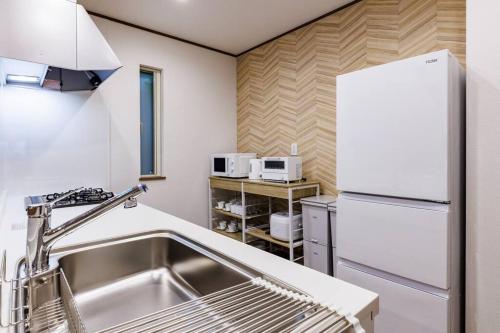 a kitchen with a sink and a refrigerator at 北谷の新築戸建て物件 周辺飲食店多数 海から徒歩5分 駐車場2台 最大10名 Hiro北谷リゾート in Hamakawa