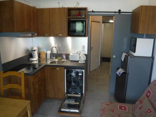 une petite cuisine avec un évier et un réfrigérateur dans l'établissement Gentianes GNB66 COSY & MOUNTAIN 3 Pers, à Châtel