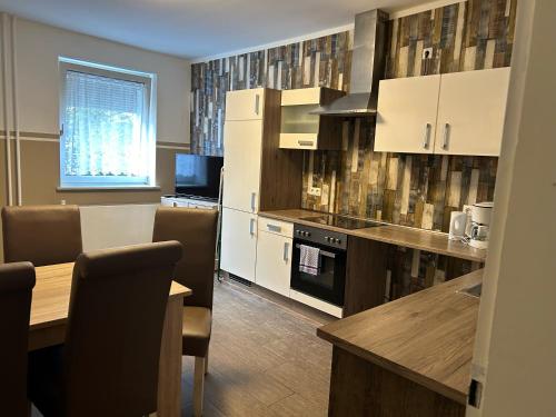 a kitchen with white cabinets and a table with chairs at Ferienwohnung in Witten
