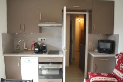 une petite cuisine avec un évier et un micro-ondes dans l'établissement Gentianes GNA15 MOUNTAIN 1 QUIET 3 Pers, à Châtel