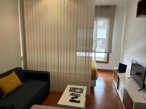 a living room with a couch and a television at Vigo Center Rooms in Vigo