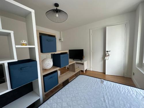 un salon avec des armoires bleues et une télévision dans l'établissement Appartement vue Scorff Lanester, à Lanester