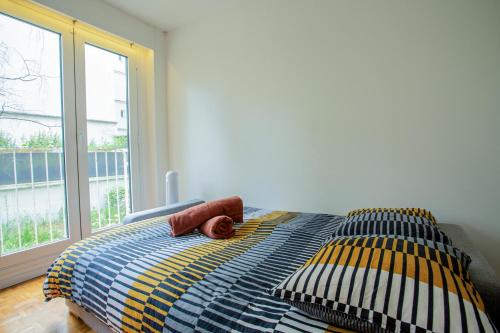 une chambre avec un lit avec un oreiller et une fenêtre dans l'établissement Elegant Escape in Paris 14th, à Paris