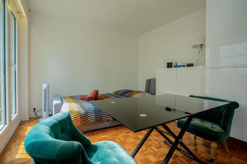 - un salon avec une table en verre et un lit dans l'établissement Elegant Escape in Paris 14th, à Paris
