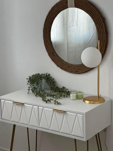 a white dressing table with a mirror and a lamp at SUNNY MOOD by Little Hellen in Perea