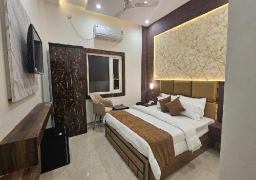 a bedroom with a large bed and a television at Triveni International in Varanasi