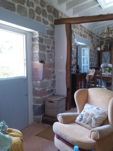 a living room with a couch and a stone wall at La Curva De María in Terán