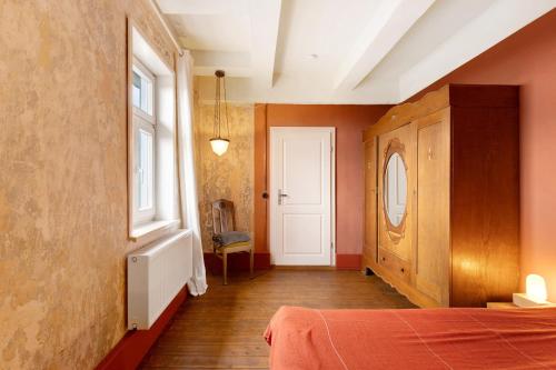 a bedroom with a bed and a window and a door at Altes Pfarrhaus - Wohnung Farbwelt in Hüttenrode
