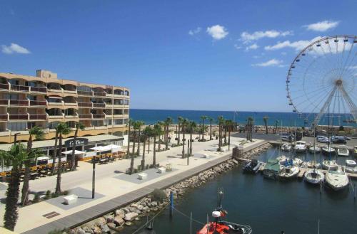 une grande roue et un port de plaisance avec des bateaux dans l'eau dans l'établissement Studio avec vue paradisiaque sur port et mer, au Barcarès