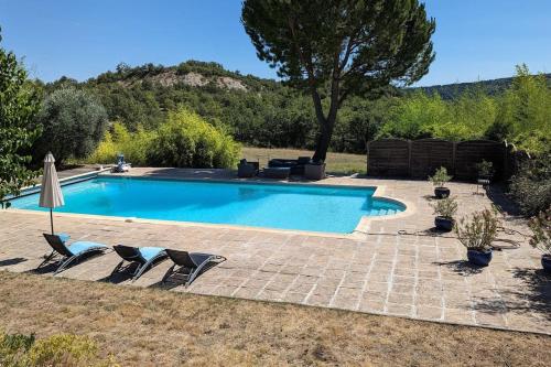 une piscine avec deux chaises et un parasol dans l'établissement Domaine Provençal 