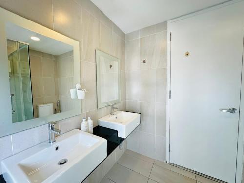 a white bathroom with a sink and a mirror at Duplex Suite Eclipse Residence Cyberjaya 2R2B by 品屋 PINWU Shortstay MMU UoC Tamarind in Cyberjaya