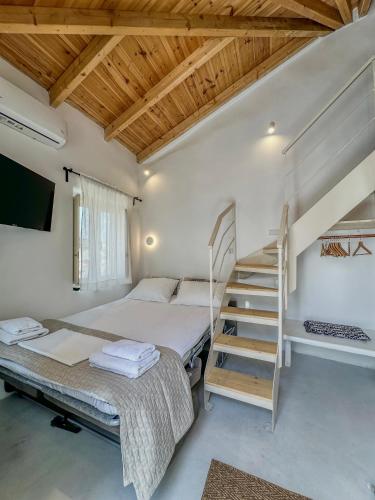 a bedroom with two beds and a staircase at Lythi Kythnos in Kithnos