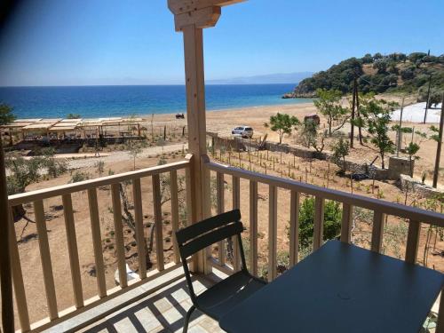 a table and a chair on a balcony overlooking the beach at Pelikastri in Promírion