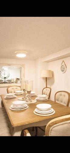 a wooden table with chairs and plates on it at The Beach House in Hastings