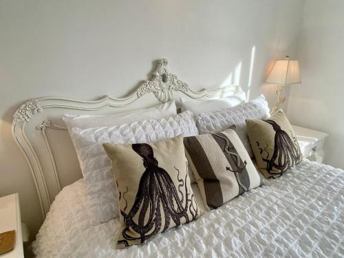 a white bed with pillows on top of it at The Beach House in Hastings