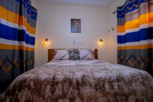 a bedroom with a bed in a room with curtains at Appart chic à louer in Lomé